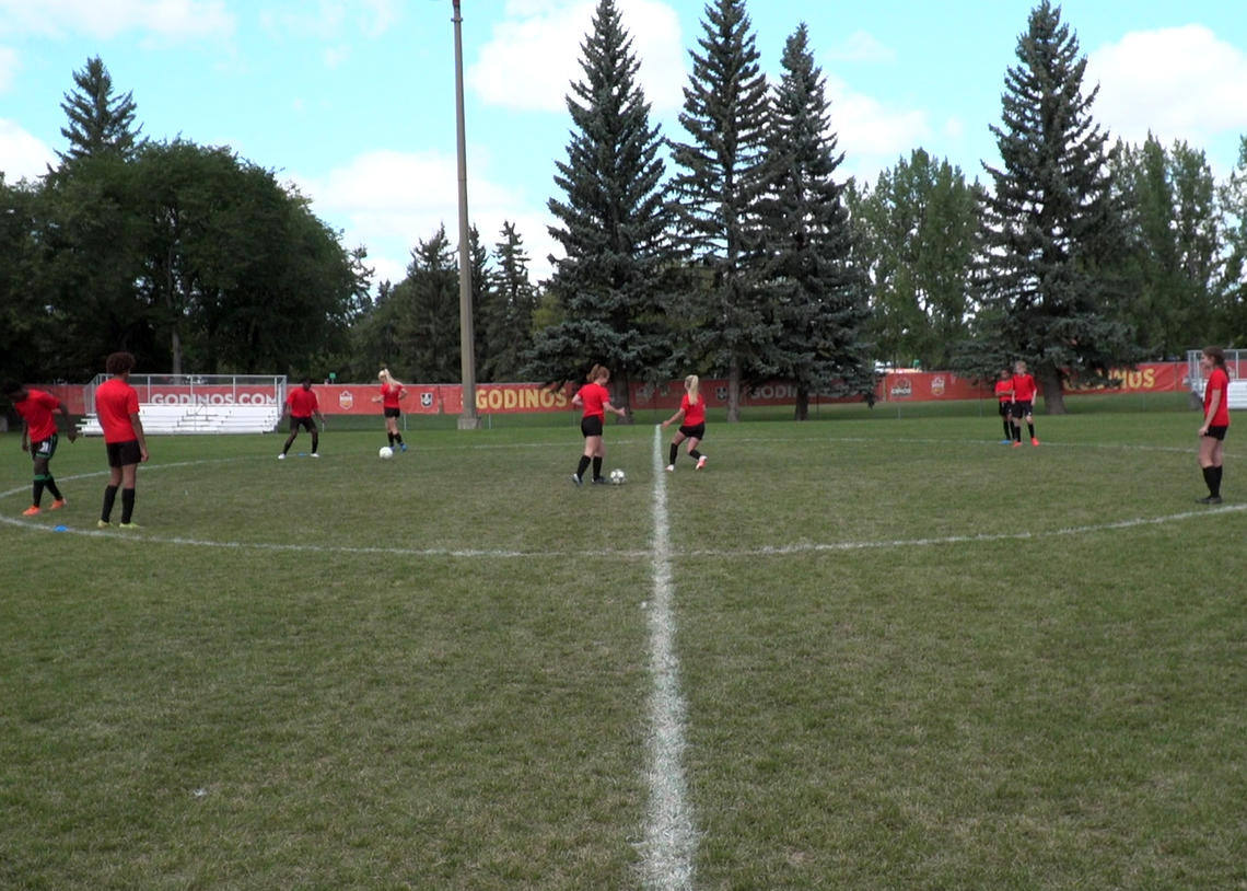 Soccer players performing pass and cut drill