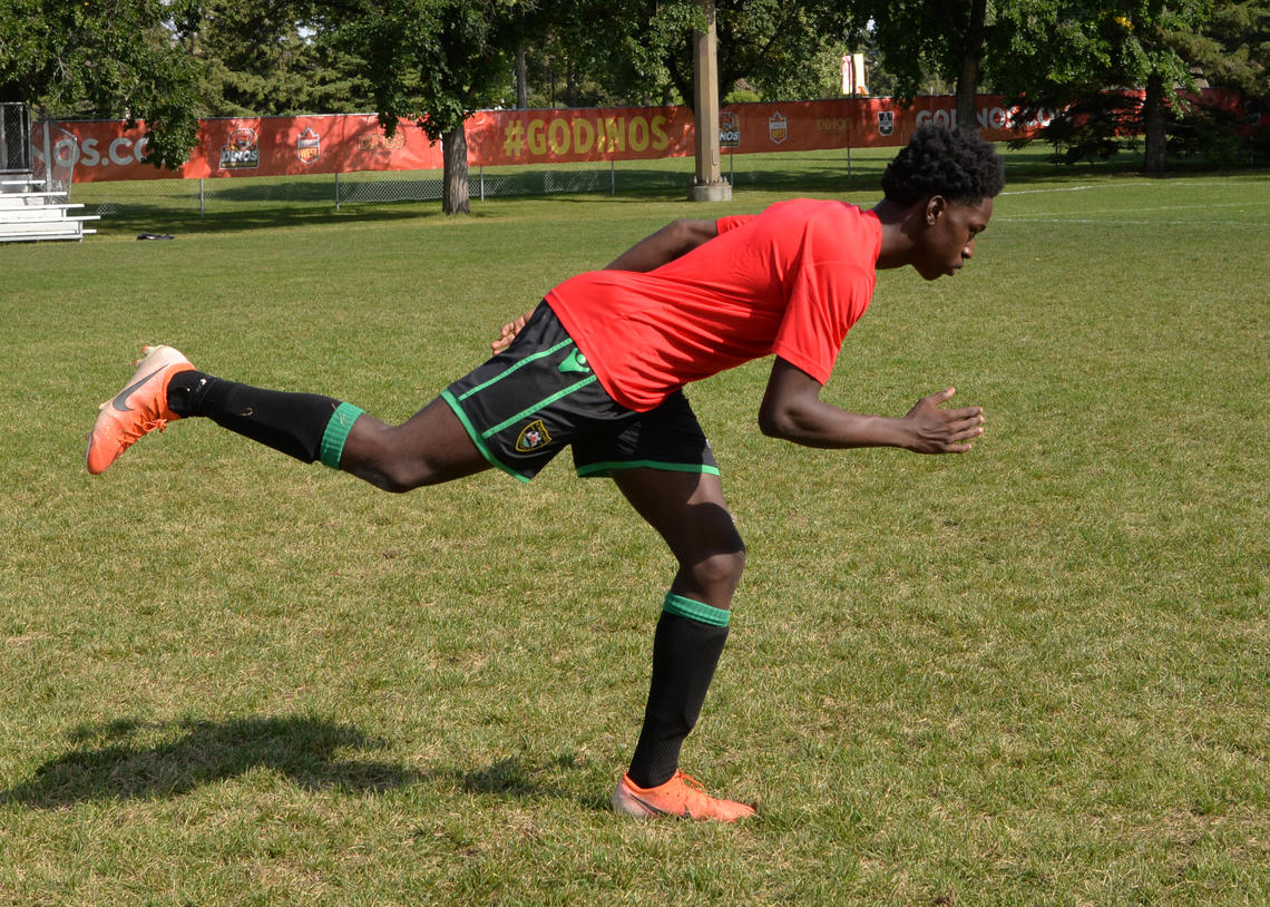 Soccer player performing airplane balance with knee drive