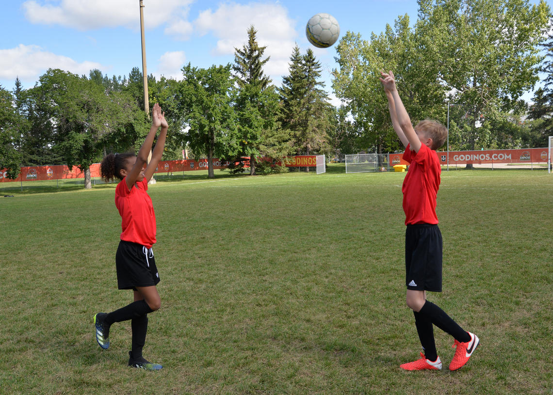 Soccer players performing overhead toss on single-leg