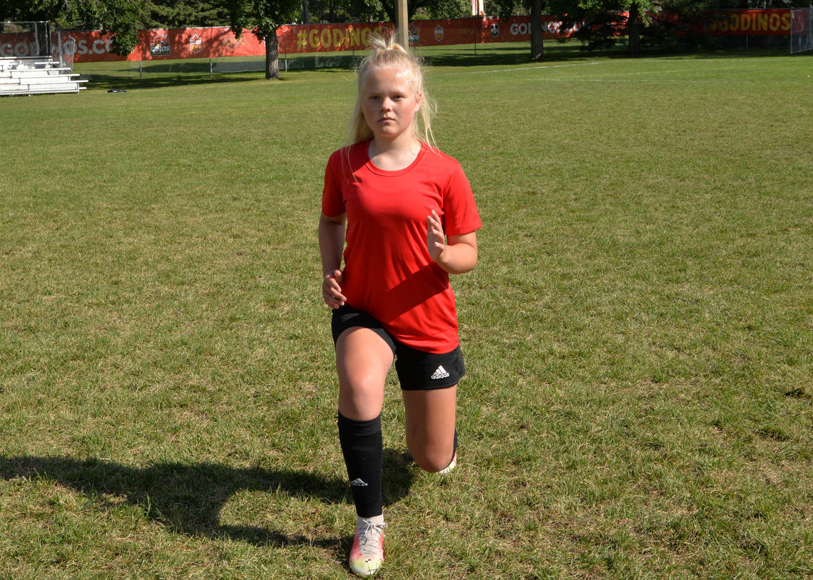 Soccer athlete performing clock lunge in the 12 o'clock direction