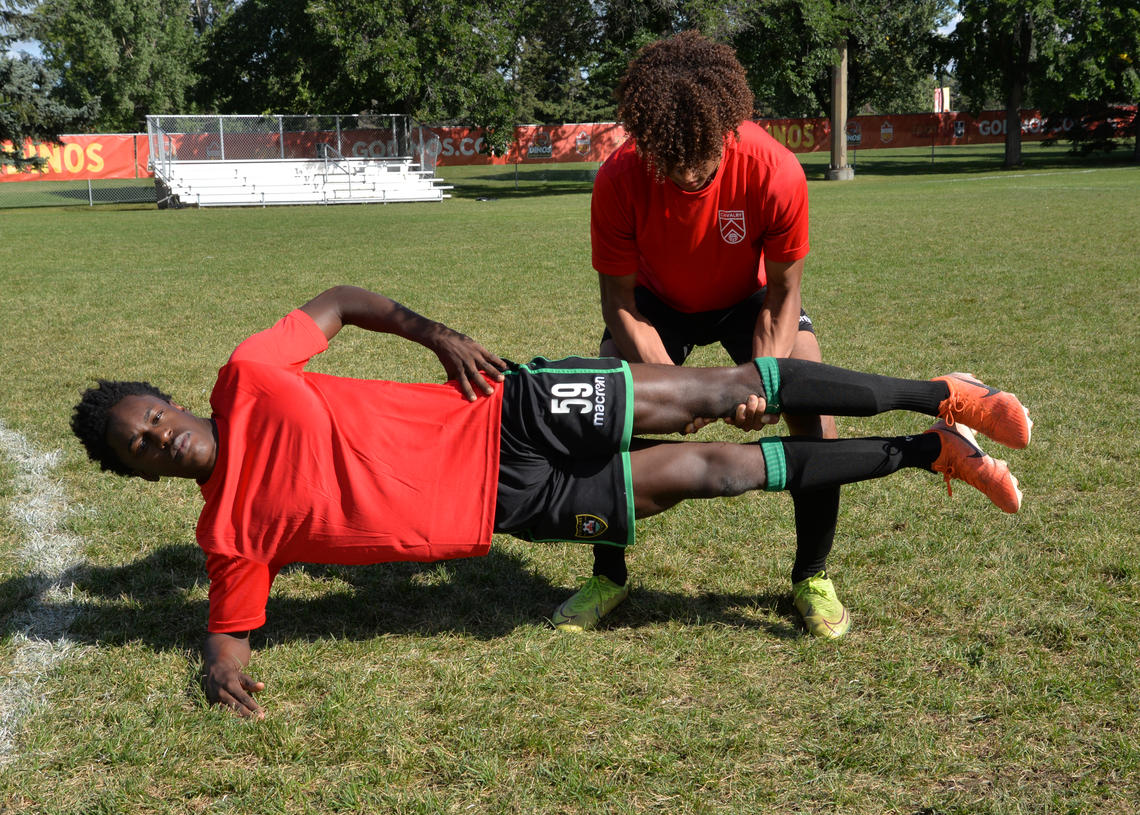 Soccer athletes performing copenhagen adductor exercise with knee support