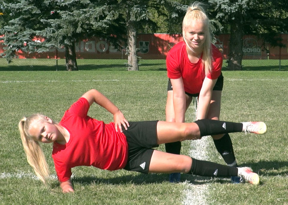 Soccer athletes performing copenhagen adductor exercise with knee-supported hold