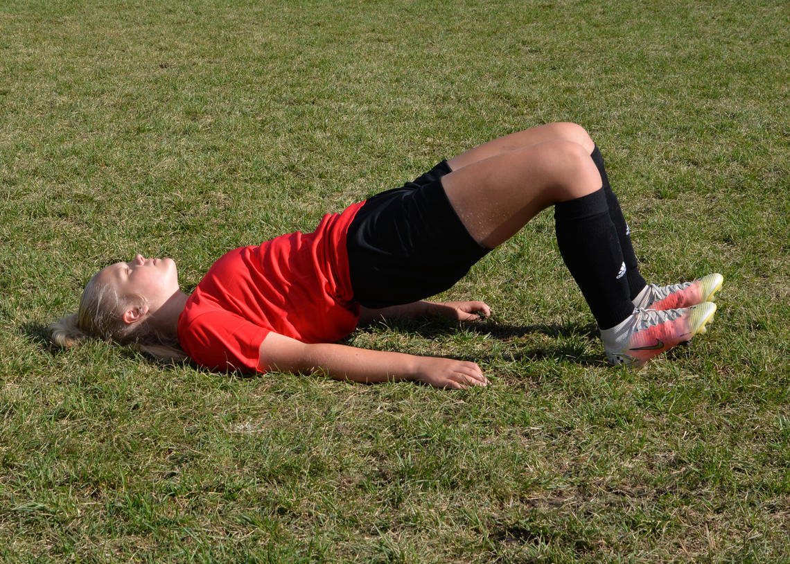 Soccer athlete performing a glute bridge