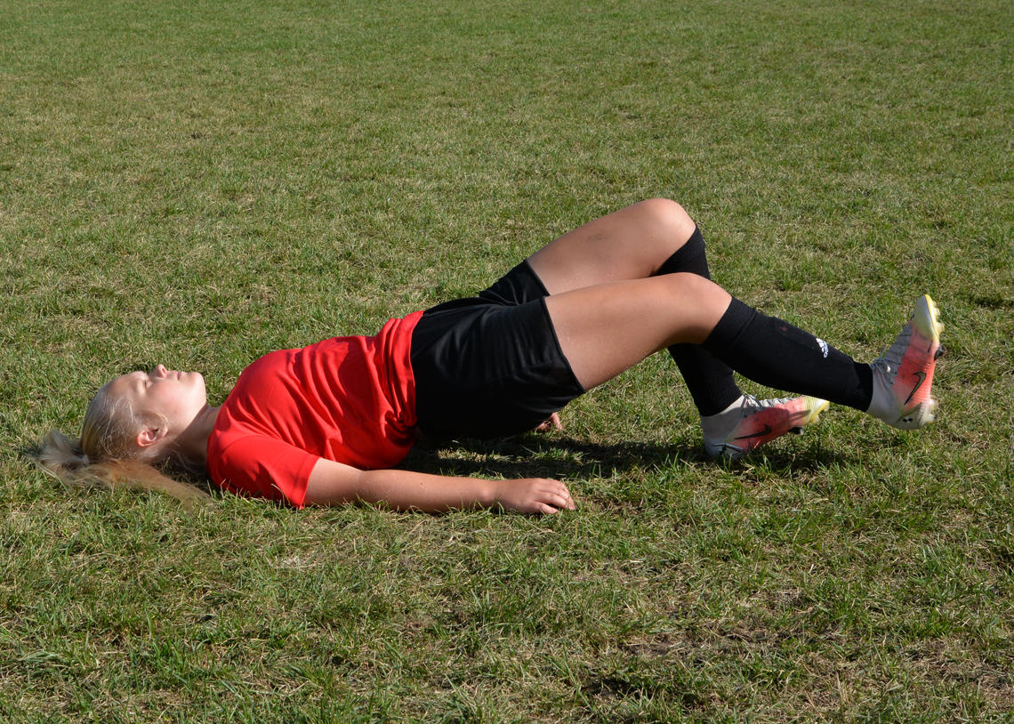 Soccer athlete performing hamstring walkouts