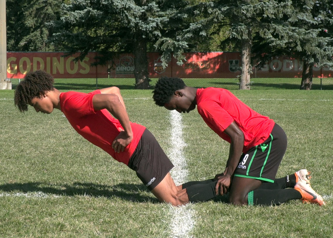 Soccer athletes performing a nordic hamstring curl with reverse