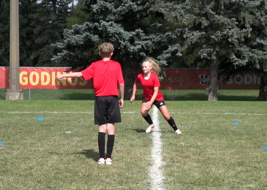 Soccer athletes performing partner plant and cut