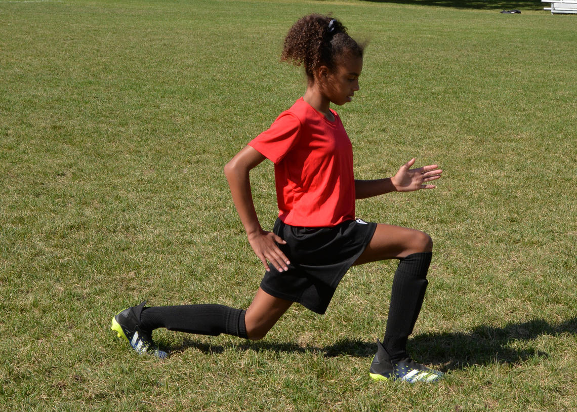 Soccer athlete performing walking lunges