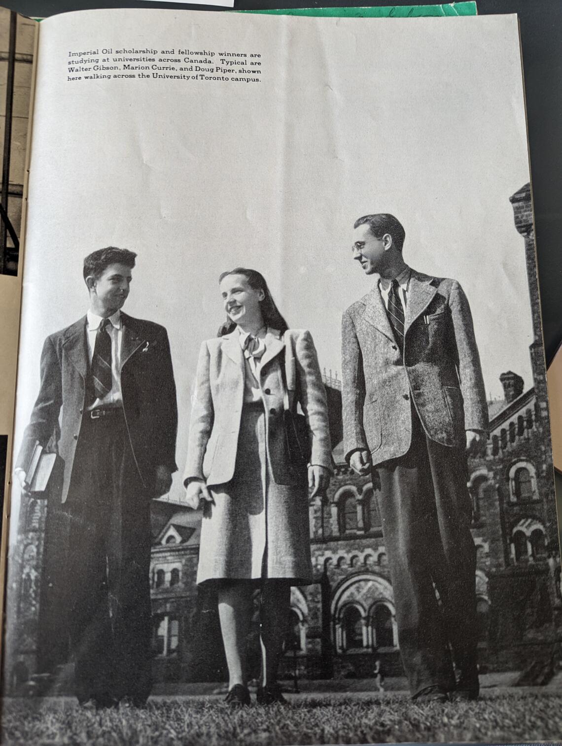 Two young man and a woman walking and talking on a university campus