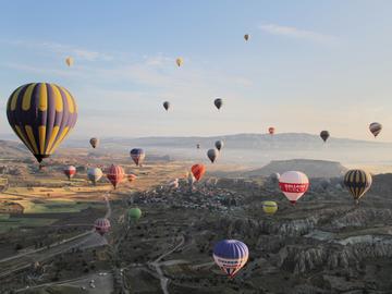 Image of many hot-air balloons over a green horizon