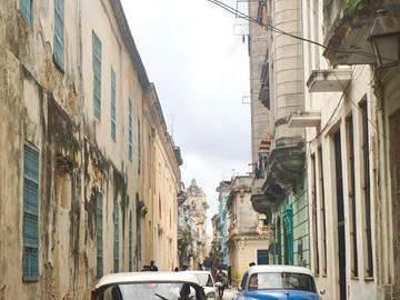 Image of old cars driving in Cuba