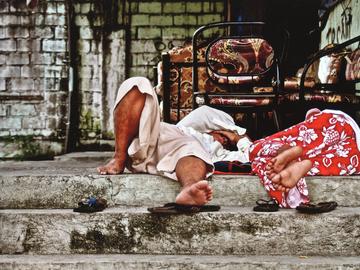 Image of two people sleeping on the sidewalk 