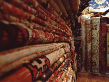 Image of Turkish fancy woven rugs close-up stacked in a shop