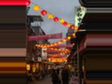 Red and gold lanterns don the streets as the sunlight is fading. 