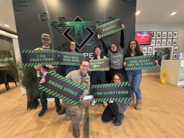 A group of seven people holding signs with silly sayings.