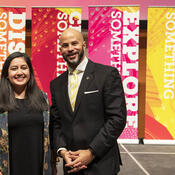 Students Union president and UCalgary Chancellor standing in front of five colourful pop-up banners
