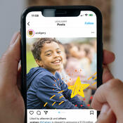 A phone in a hand showing an Instagram feed