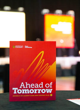 A report propped up on a table in front of a stage