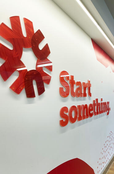 Start something wall graphics including raised plexiglass spark and wordmark