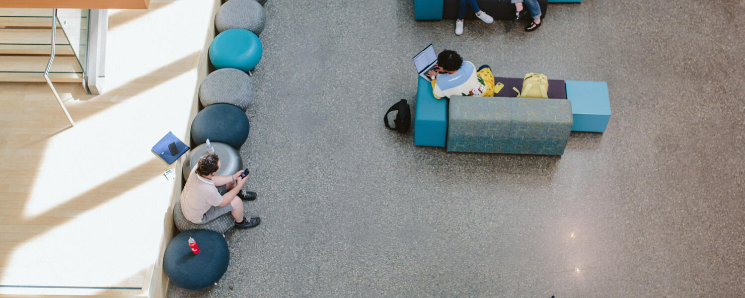 Looking down on students sitting in the atrium at the Taylor Institute for Teaching and Learning.