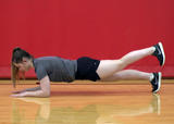Athlete performing front plank on elbows with leg lifts