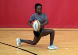 Athlete performing walking lunges with torso rotation and leg lift exercise