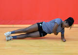 Athlete performing side plank with torso rotation exercise
