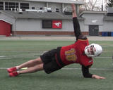 Football athlete performing front plank on elbows with rotation