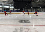 Hockey players performing a 3-player weave drill on a hockey rink