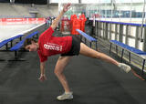 Athlete performing airplane balance with external hip rotation exercise in an ice hockey arena