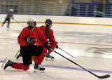 Hockey players performing lunges with rotation exercise on a hockey rink