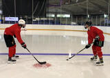 Hockey players performing vestibulo-ocular reflex with stick handling exercise on a hockey rink