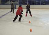 Ringette players performing a figure 8 passing drill with a shoulder check on ice