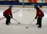 Ringette players facing each other performing head shakes for vestibulo-ocular reflex while maintaining their eyes fixed on their partner's jersey logo