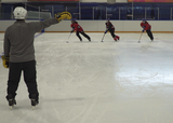 Ringette players performing a reaction change of direction exercise, cutting into the opposite direction that the coach points to