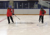Ringette players performing single-leg glides with passing