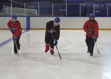 Ringette players performing single-leg glides across a rink