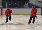 Ringette players performing vestibulo-ocular reflex with stick handling exercise on a rink