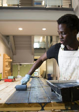 University of Calgary Laboratory for Integrative Design Research Assistant Nicolas Hamel lines up a guide as he helps to construct the Furbaniture wood panels for the Walk21 project