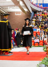 Woman walking across the stage at Convocation