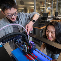 Students working with a 3D printer