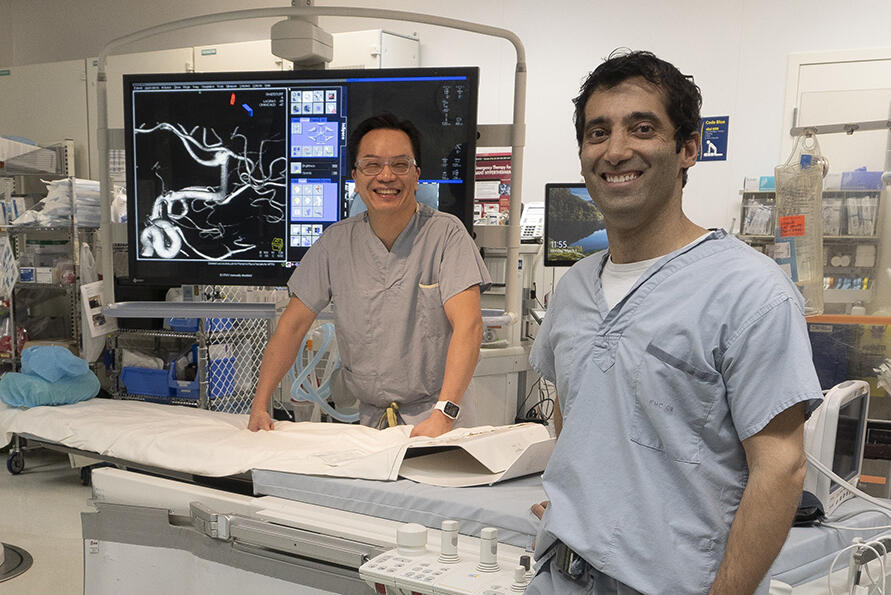 Two men stand in an operating theatre