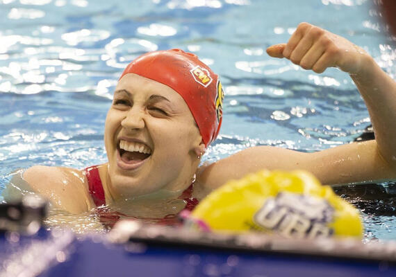 A woman celebrates in a pool